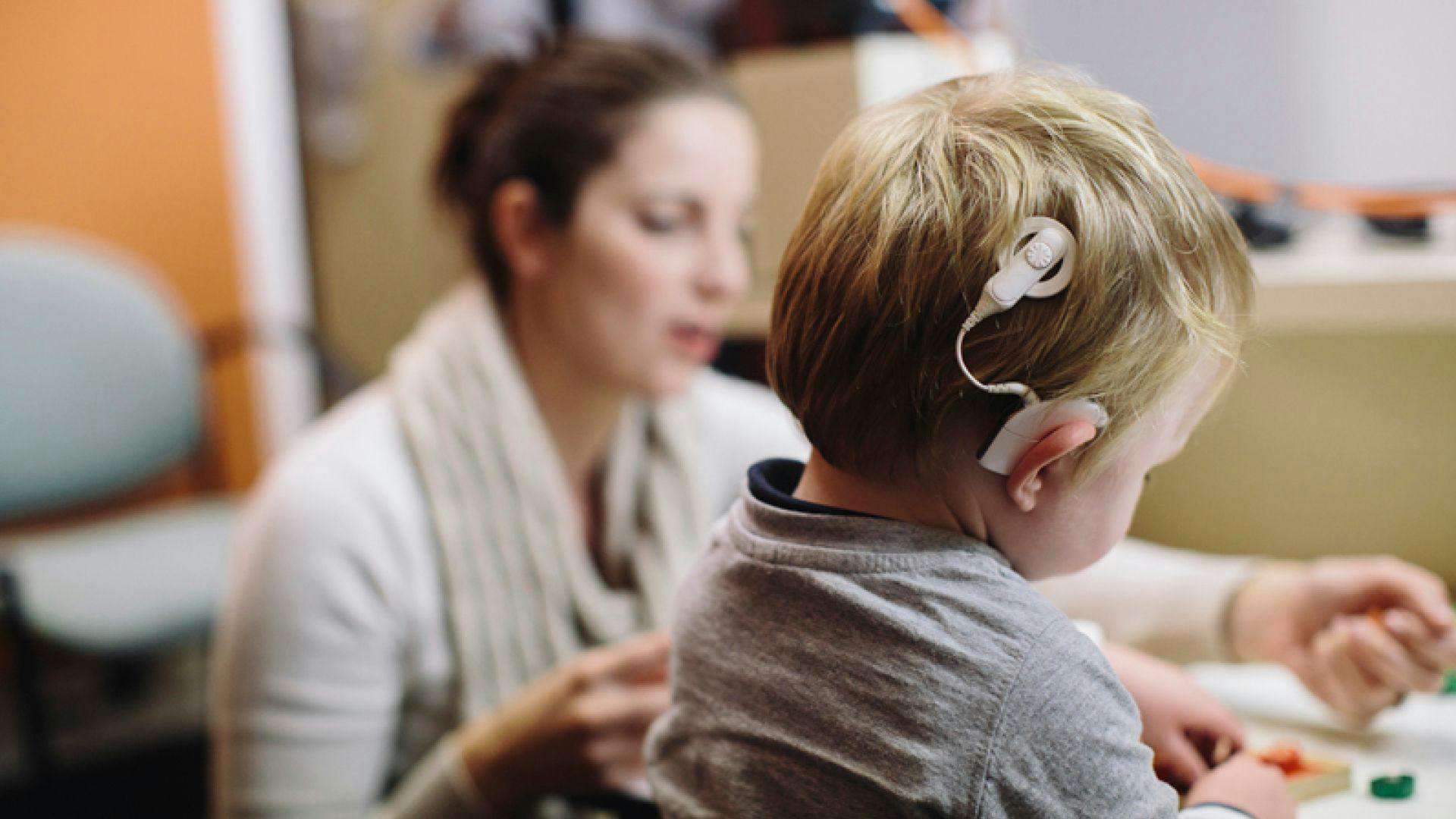 A child with a cochlear implant and parent